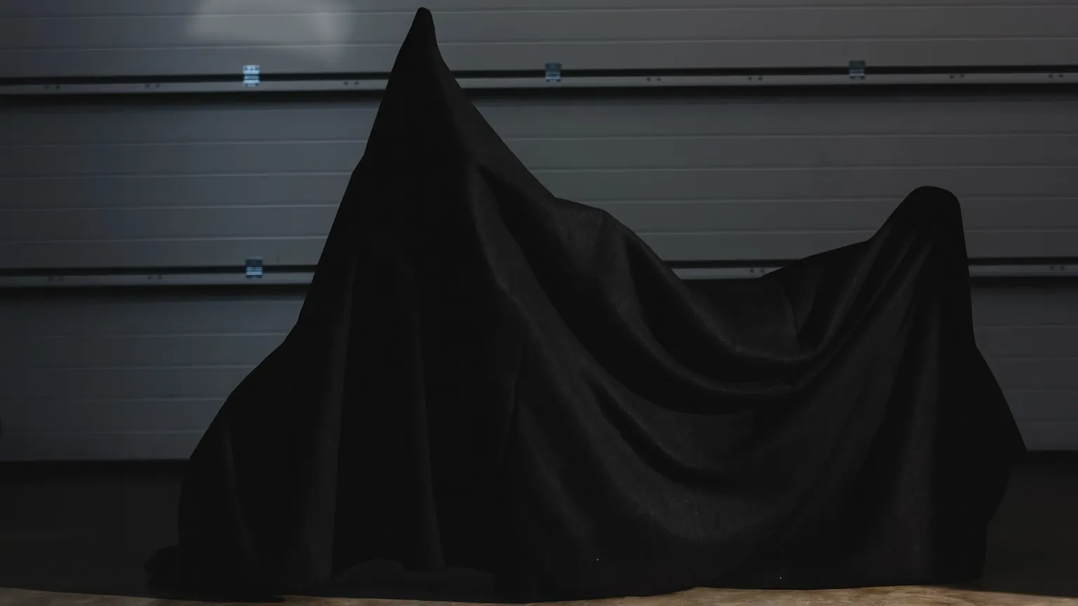Une moto recouverte d'un drap noir prête à être remiser.