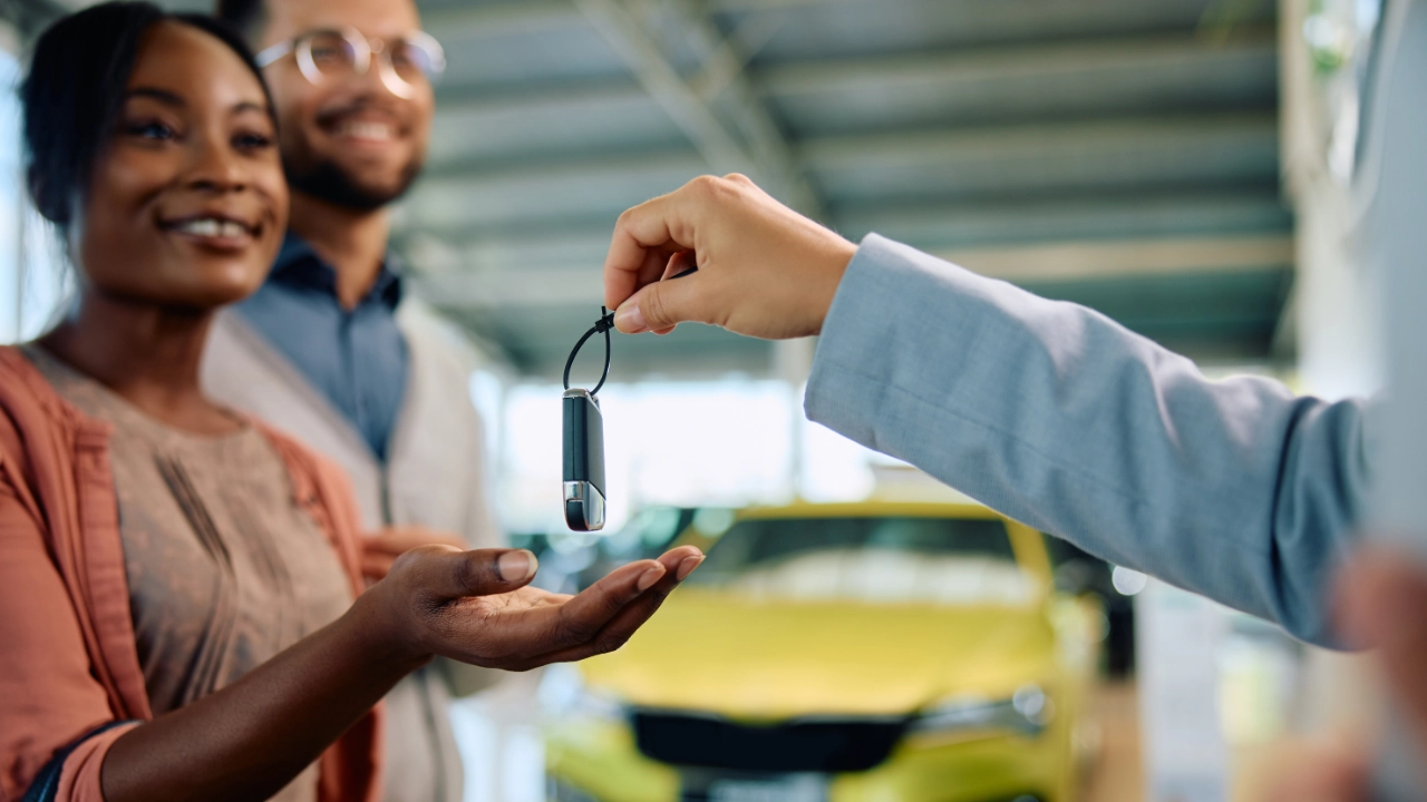 couple receiving the keys of their new car