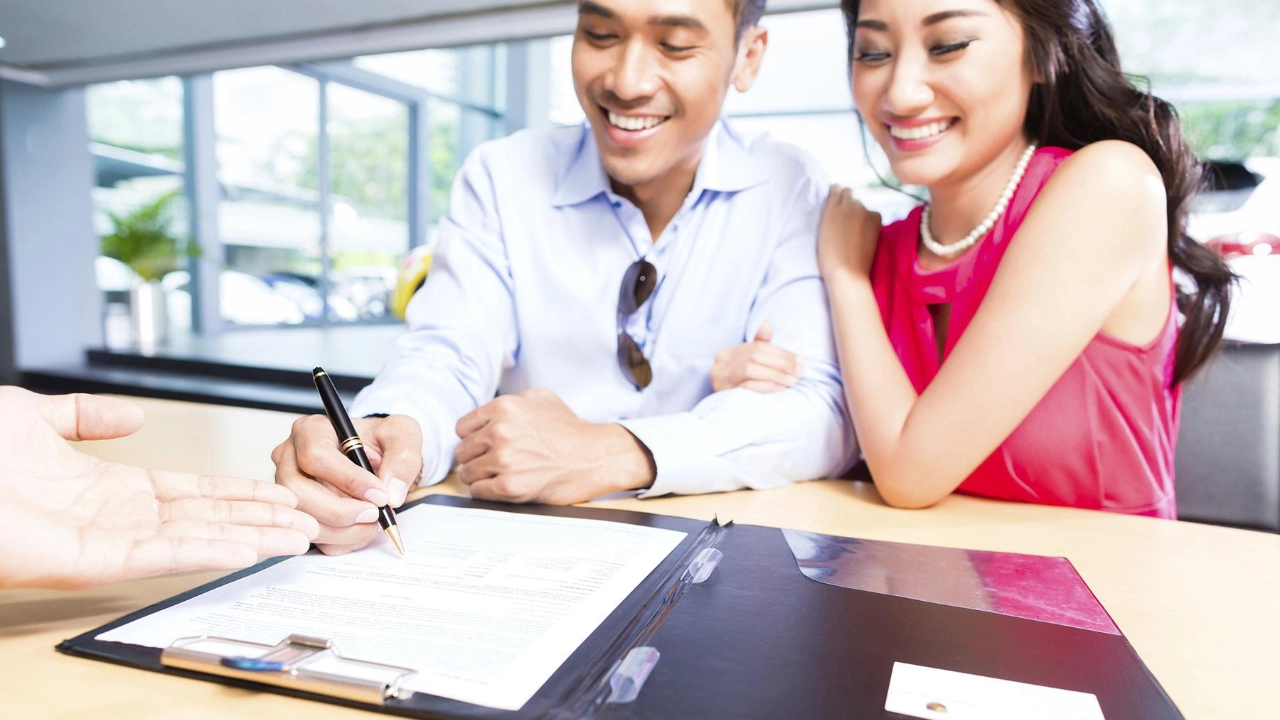 couple signing a contract to finance their car