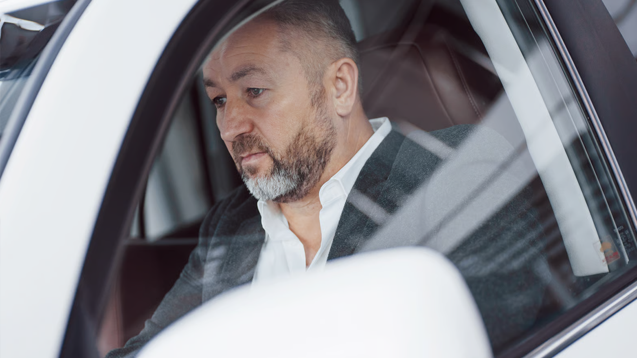 Un homme d'affaires travailleur autonome sérieux teste une nouvelle voiture