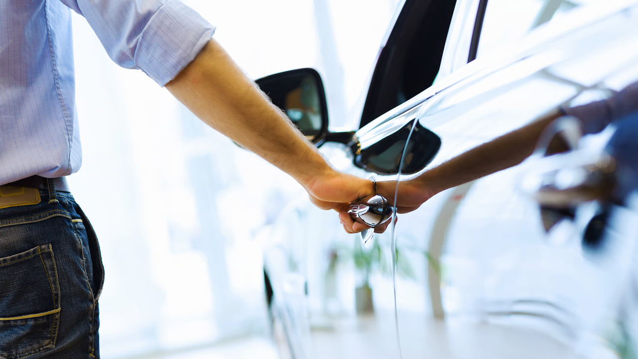 Homme pensant vendre sa voiture pour une nouvelle