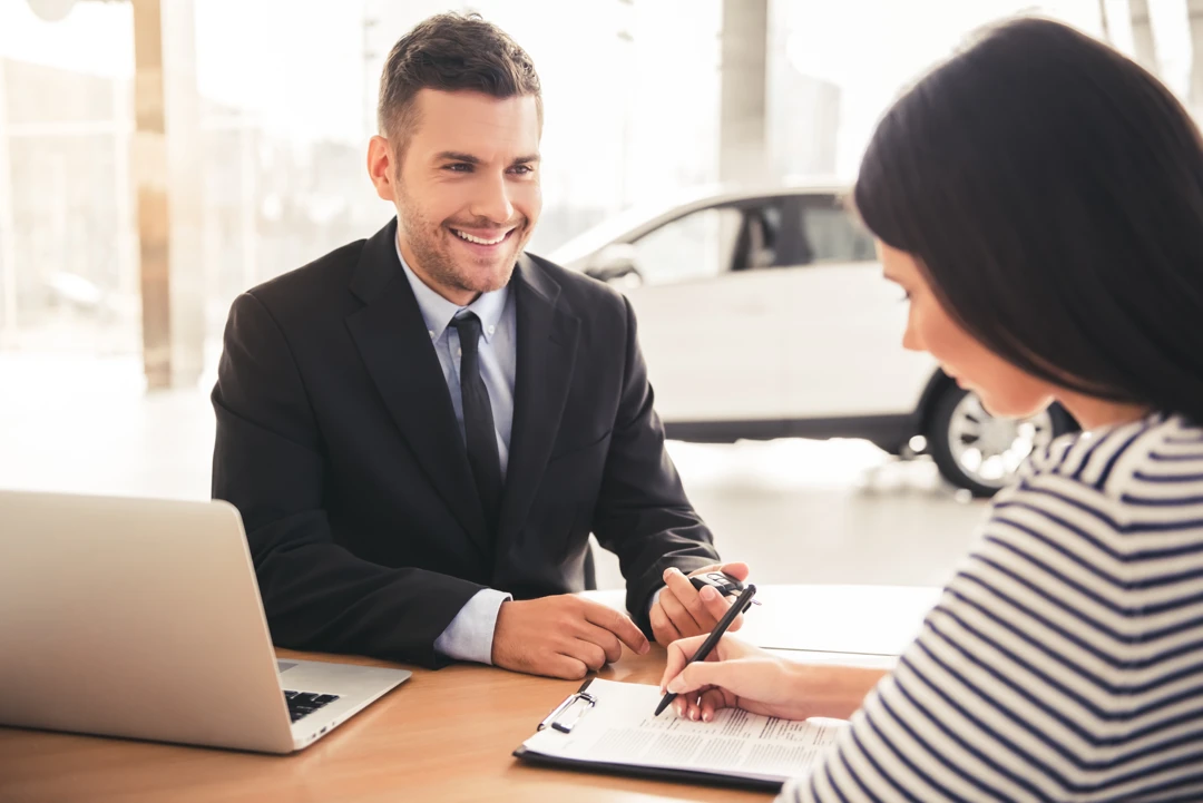 Customer signing documents with an advisor to prepare an auto financing application in Montréal.