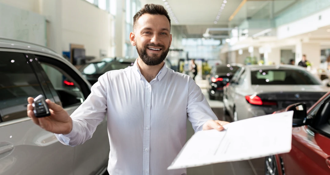 Auto financing advisor presenting a car key and loan documents to illustrate second-chance credit solutions.