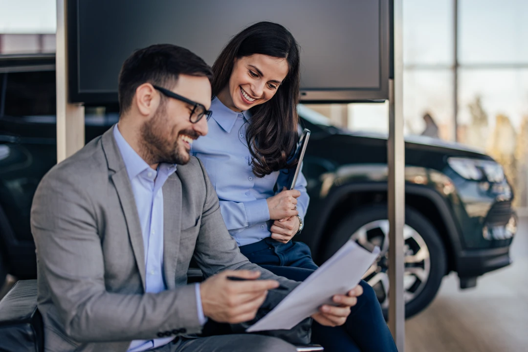 Financial advisor and customer reviewing documents to choose auto financing tailored to the customer's credit profile.