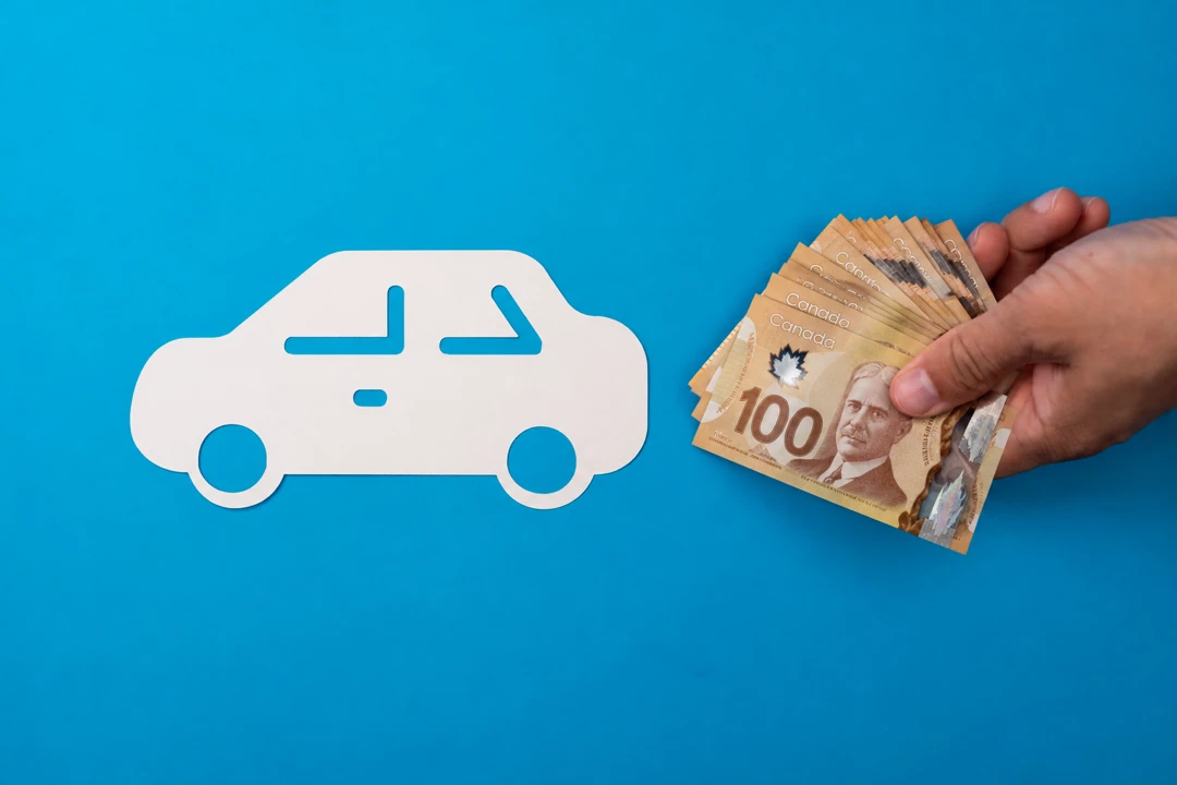 Hand holding Canadian banknotes beside a car silhouette, illustrating a down payment for an auto loan.