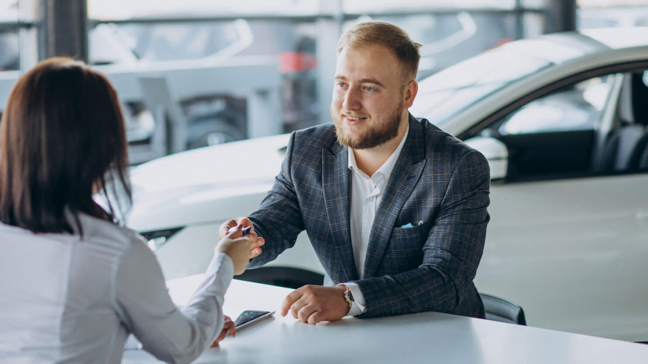jeune homme en train de finaliser l'achat d'un véhicule