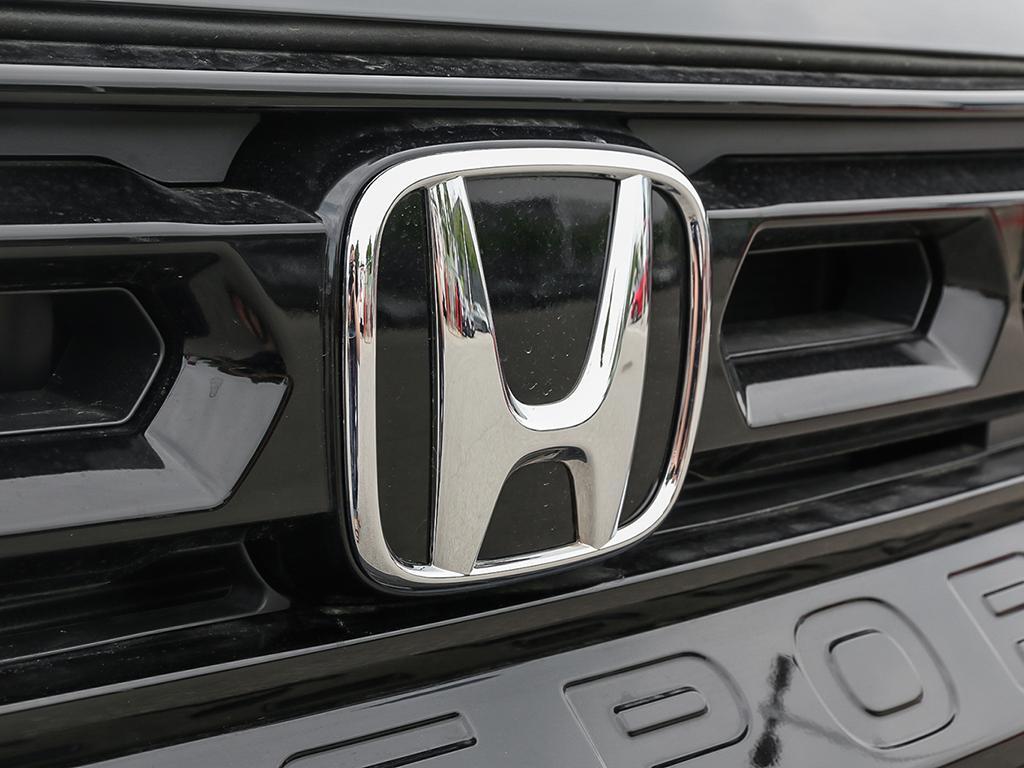 2026 Honda Passport TrailSport AWD in black, close-up of Honda logo on grille